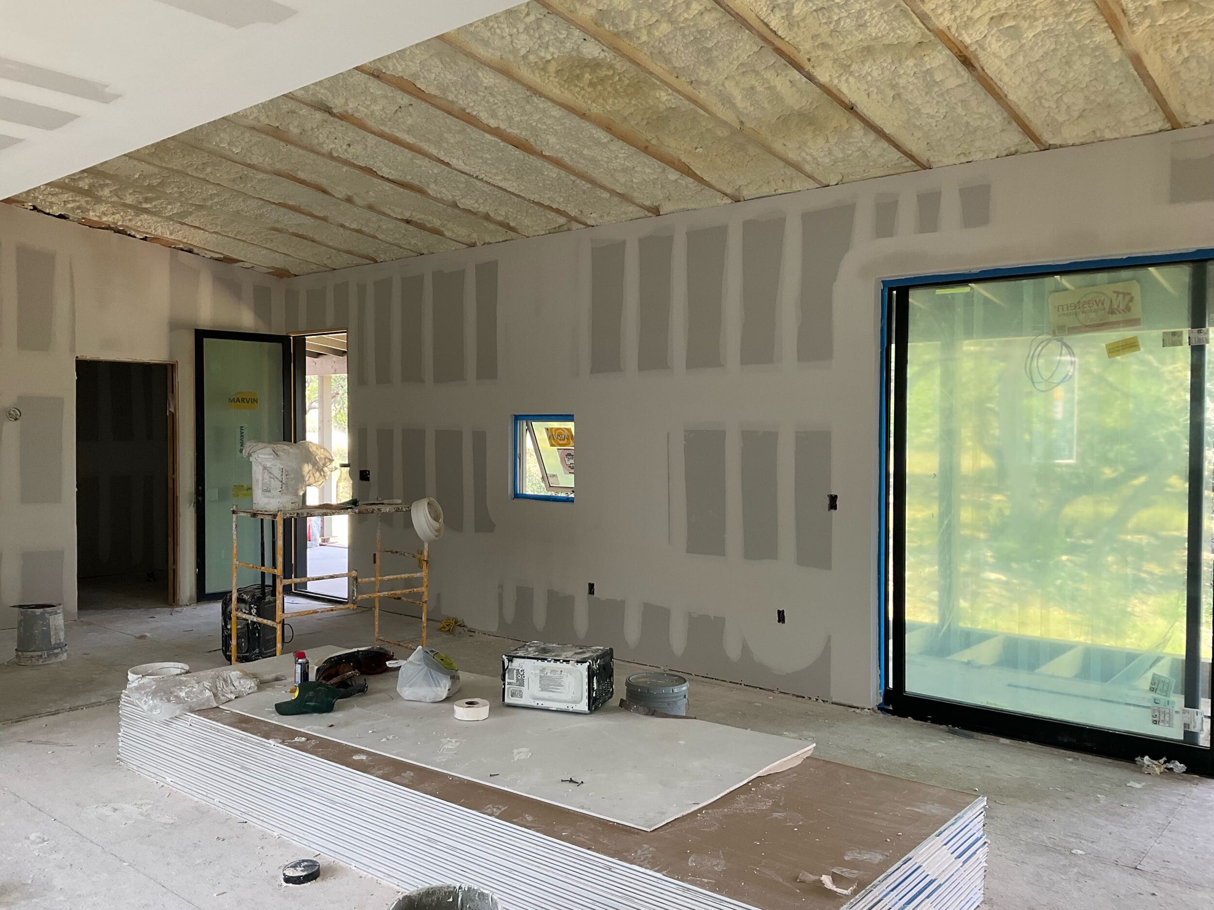 Interior rooms with finished drywall installation, ready for painting and finishing