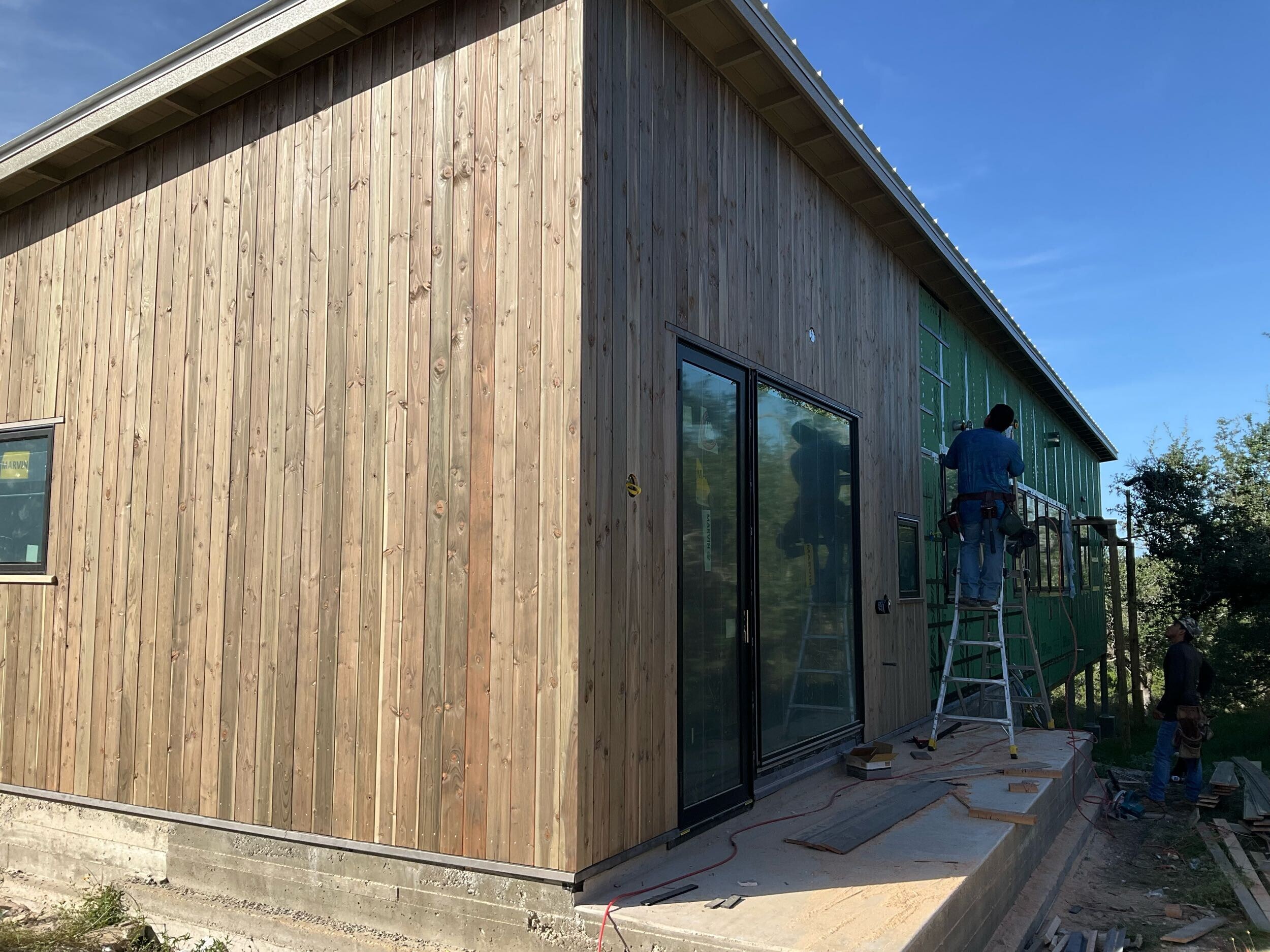 House exterior with finished siding installation, showing the complete outer shell